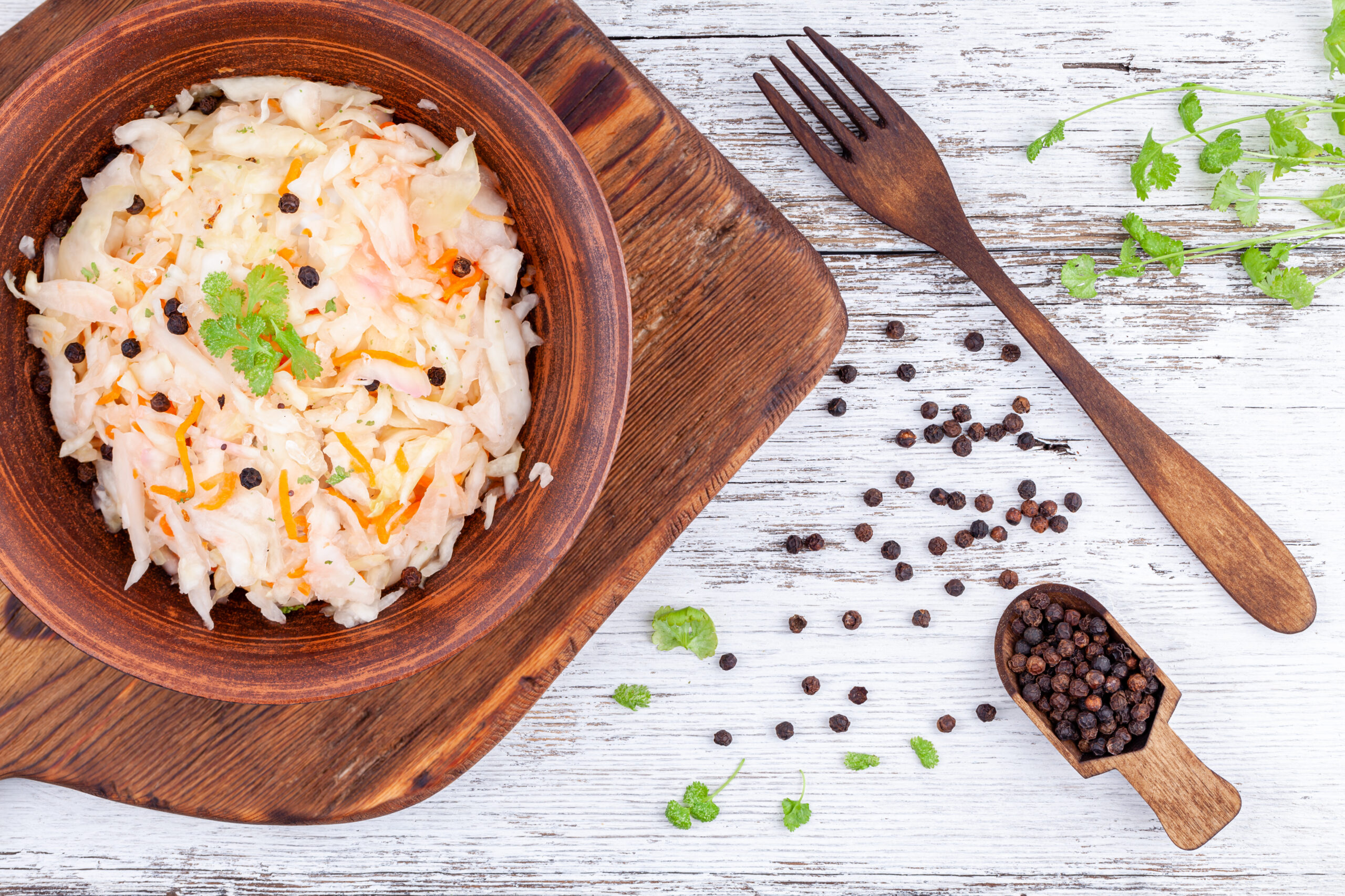 Fermented foods in a bowl with herbs sprinkled around helps gut microbiome and immune disease.