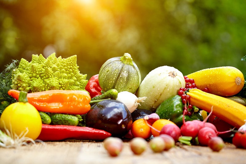 Frutas y vegetales orgánicos frescos sobre una mesa de madera, mostrando que la nutrición es una excelente alternativa a los opioides.