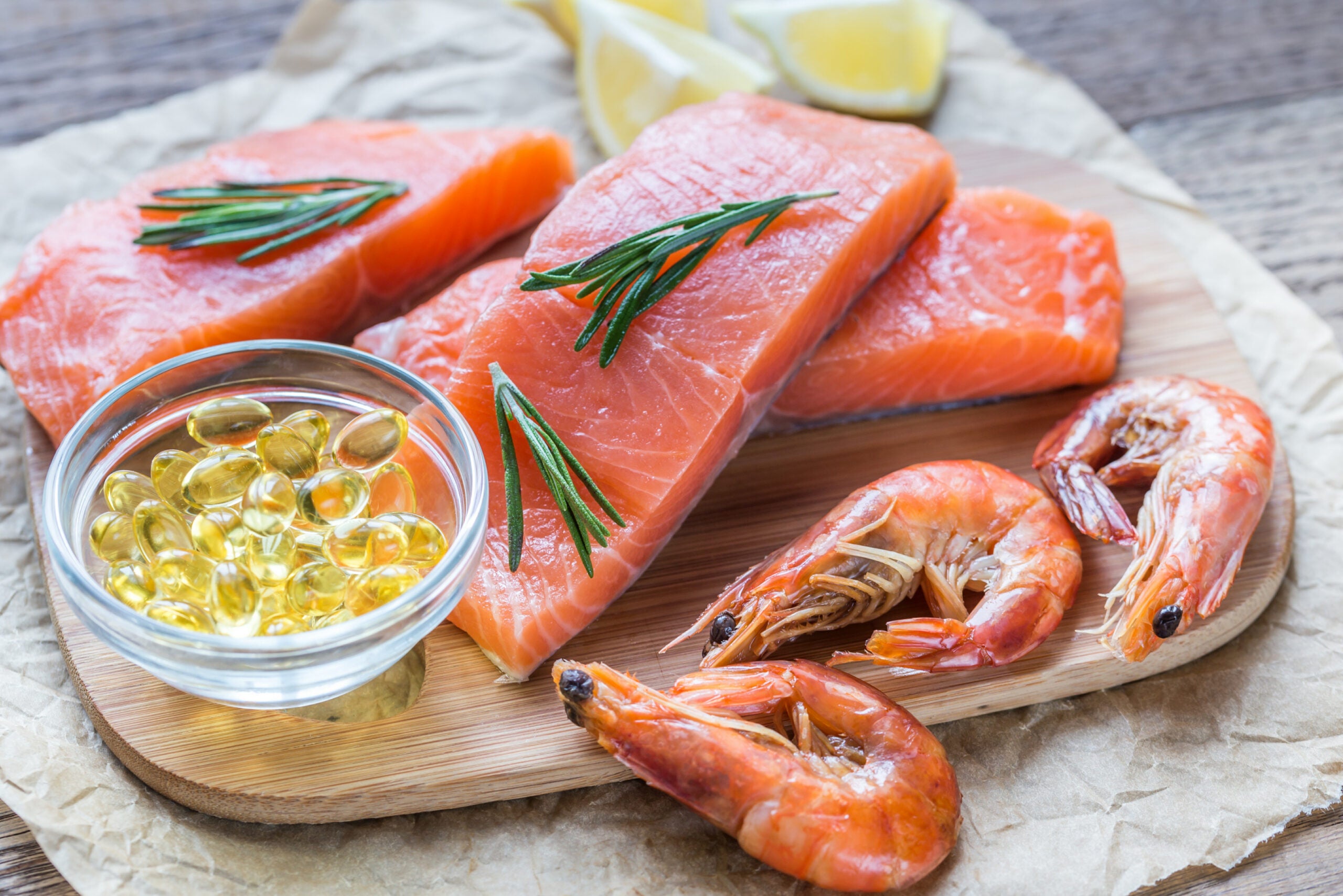 Vista plana de fuentes de grasas saludables, salmón y camarones que componen la dieta cetogénica, uno de los tratamientos de medicina funcional para las migrañas crónicas.