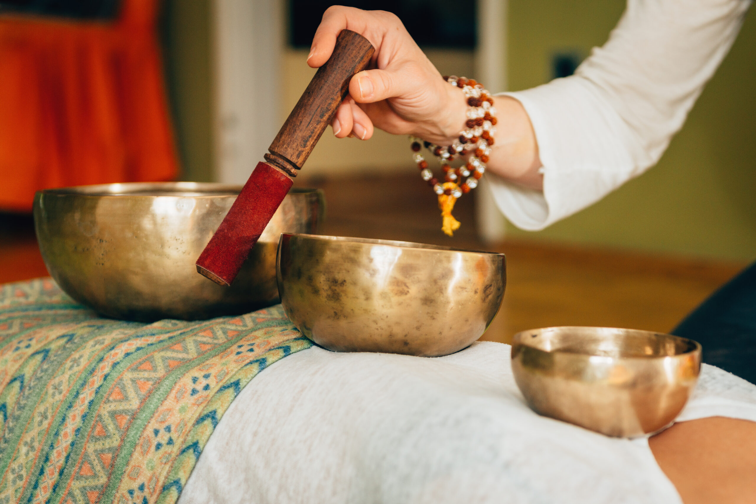 Persona realizando una terapia espiritual con cuencos tibetanos. La terapia con sonido, como esta, puede tener beneficios en la reducción del estrés y en la mejora del bienestar cardiovascular.